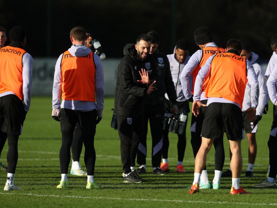 Carlos Corberán delivering a message to several players in the middle of a session 