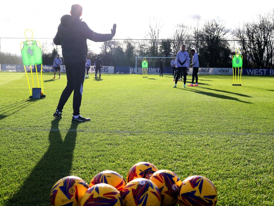 A general view of training with yellow footballs at the front 