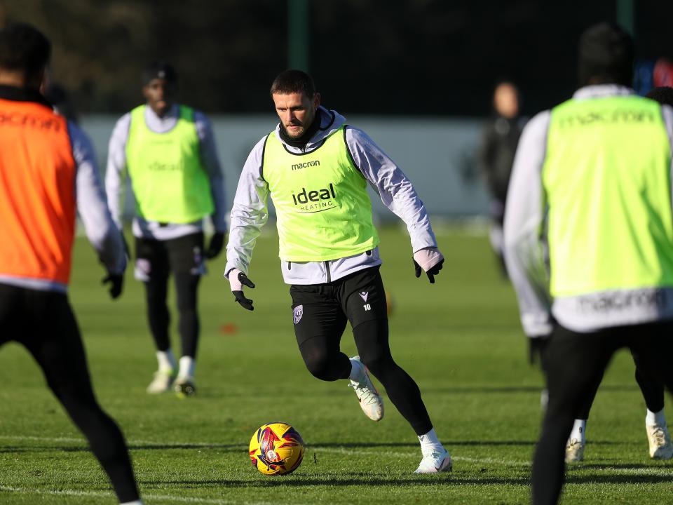 John Swift on the ball during a training session wearing a yellow bib
