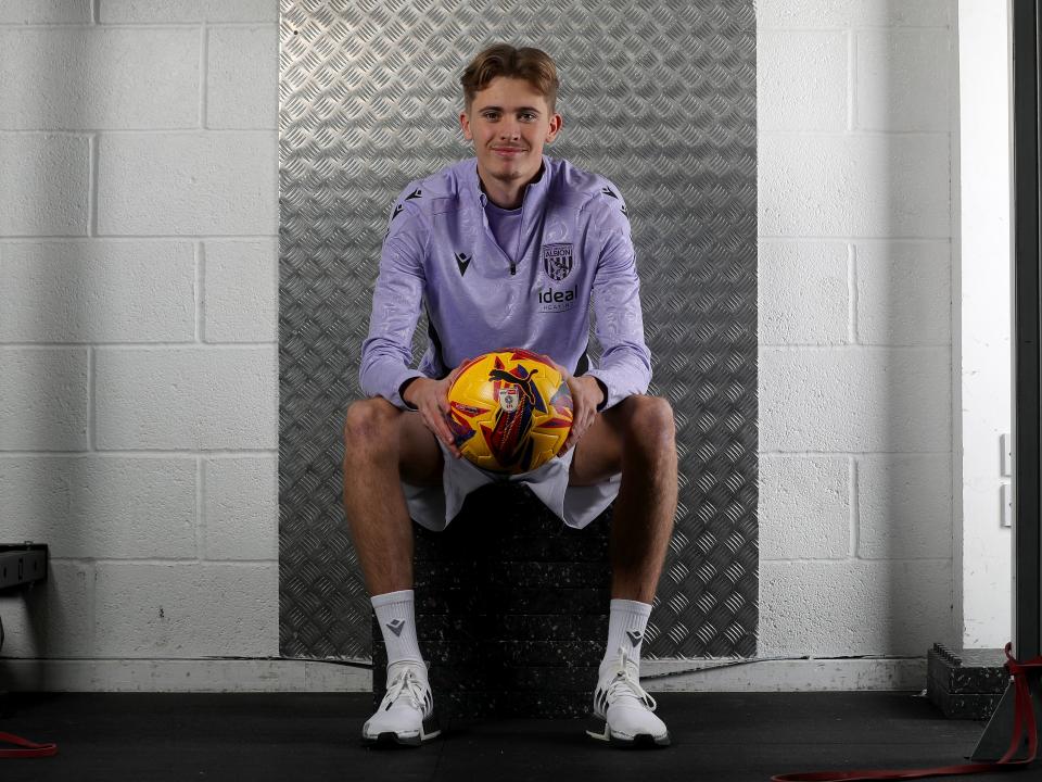 Isaac Price sat down holding a yellow ball