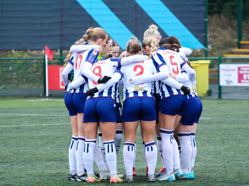 Albion Women in a team huddle.