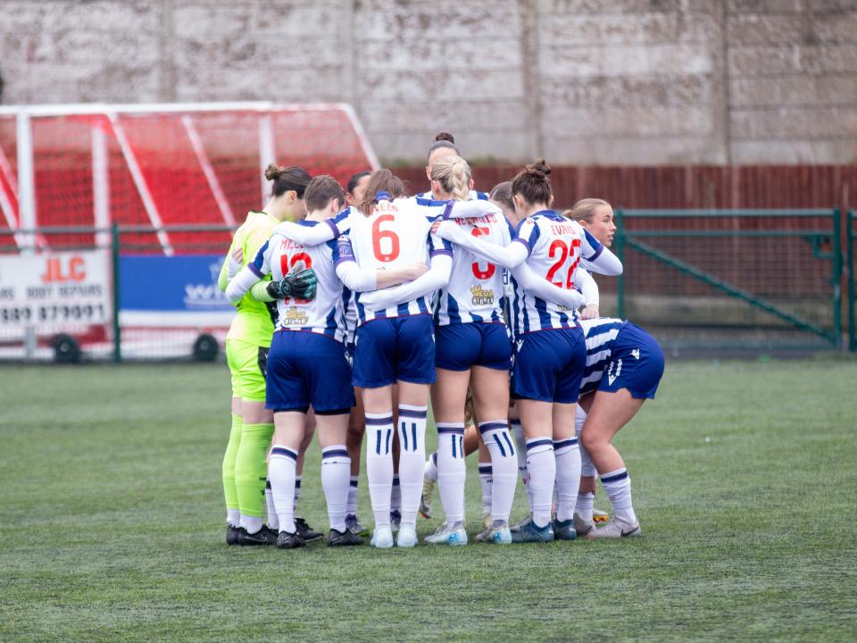An image of the Albion Women players in a huddle