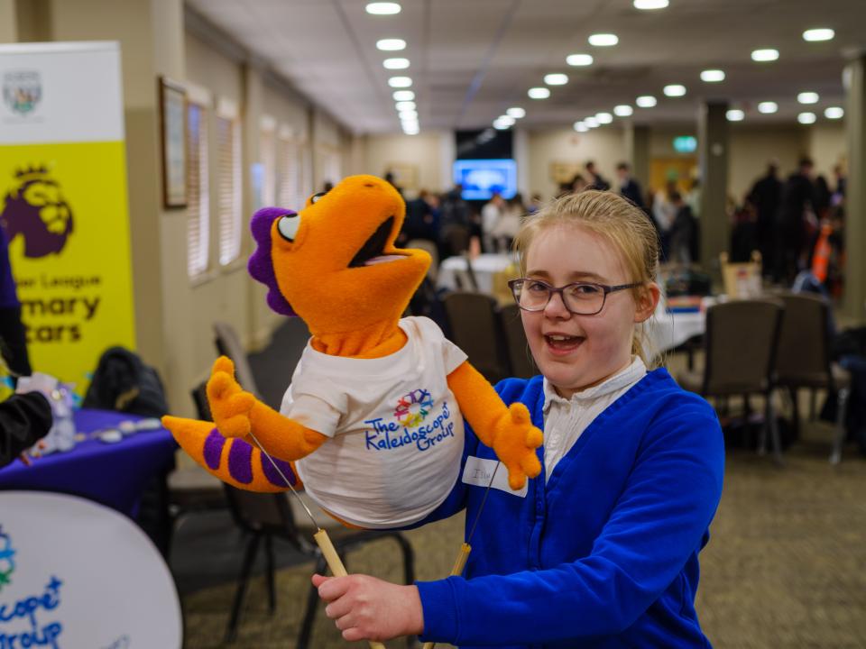 A child holds the Kaleidoscope puppet.