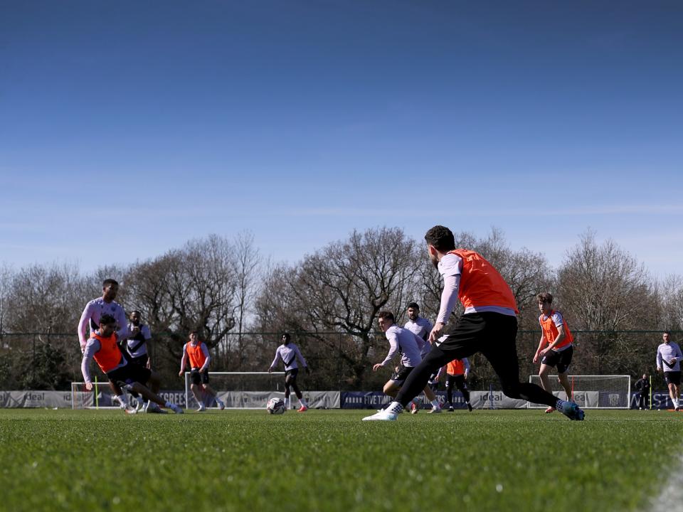 A general view of training in the sunlight with several players in shot