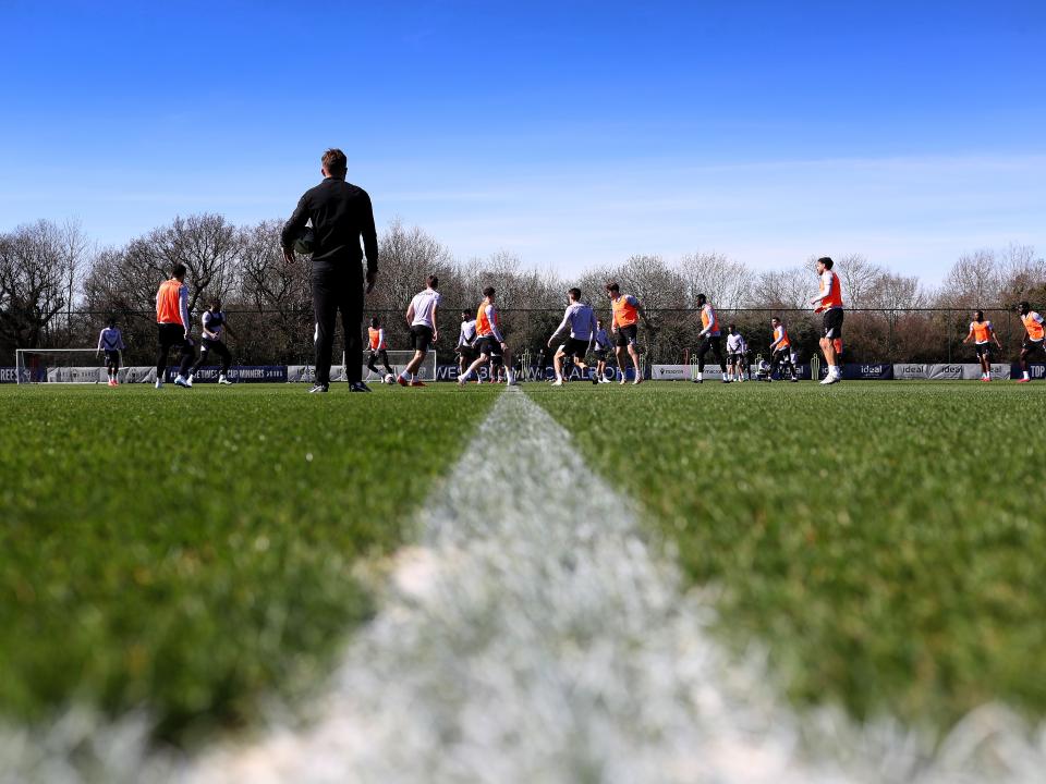 A general view of training with several players in shot and a white line on the pitch 