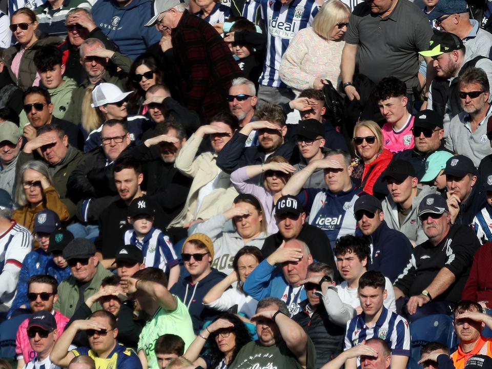 Albion fans shield their eyes from the sun in the stand at The Hawthorns 