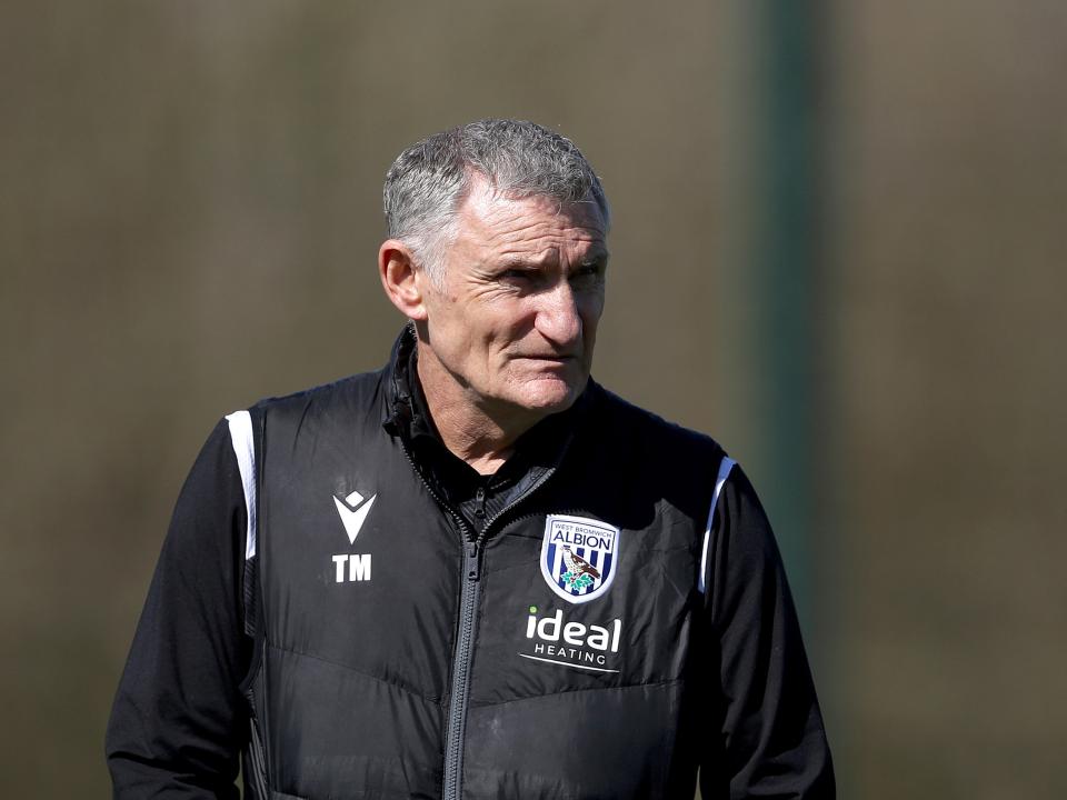 Tony Mowbray watching training while wearing a black WBA coat