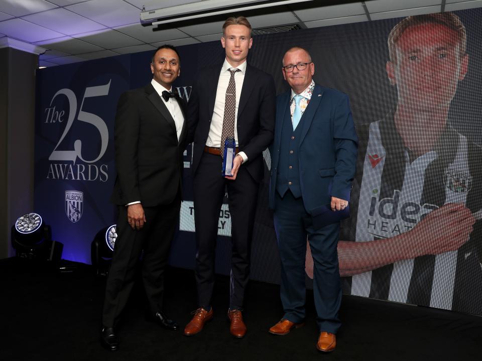 Shilen Patel and Torbjørn Heggem pose for a photo with a sponsor on stage at the end of season awards dinner