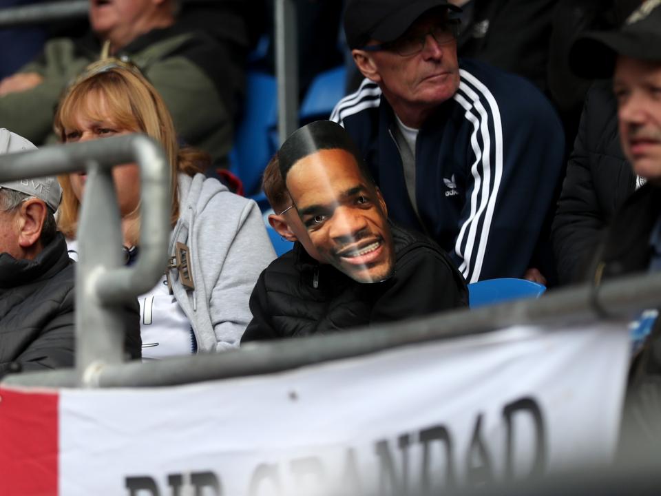 An Albion fan with a Grady Diangana mask in the away end at Cardiff