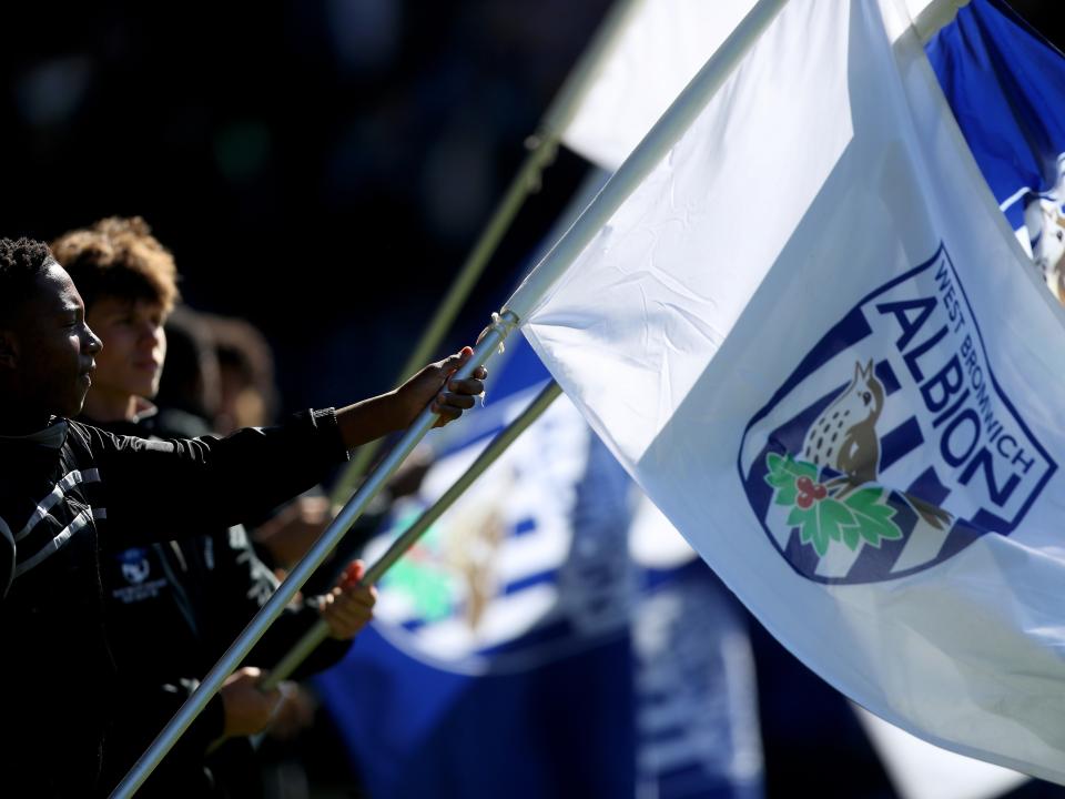 An image of Academy players waving the giant flags