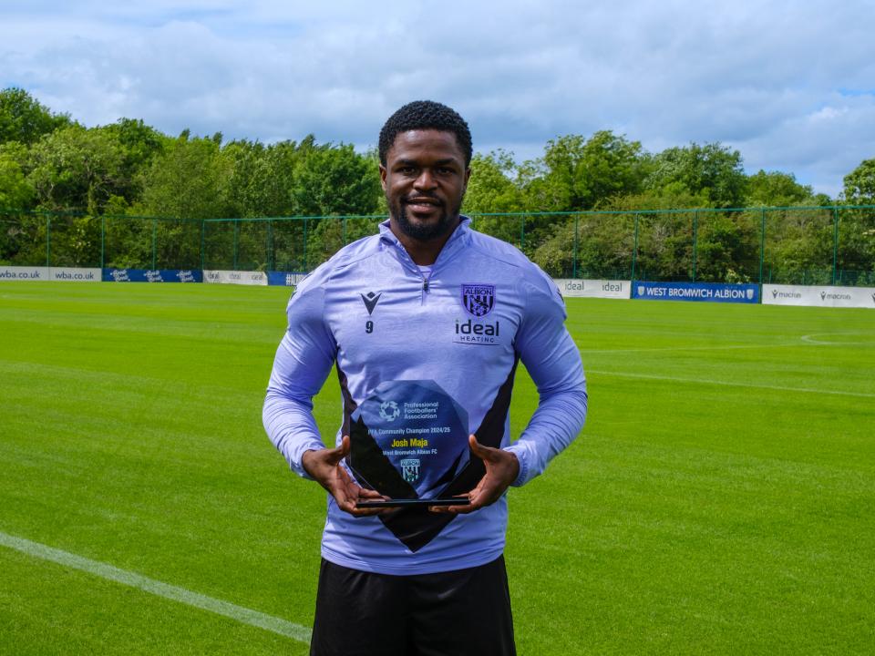 Josh Maja holding this PFA Community Player of the Season award at the training Ground.