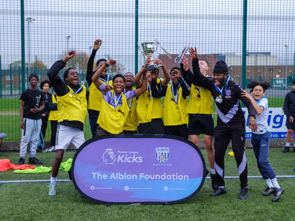 Group of young participants celebrating a trophy lift.
