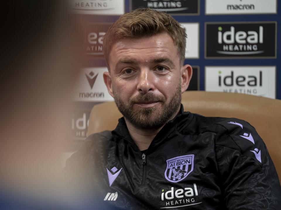 James Morrison is interviewed by the media in front of the press conference sponsor board