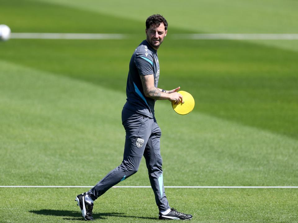 Ryan Mason walking during a training session with a cone in his hand