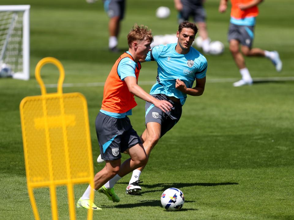 Ollie Bostock on the ball during training with Caleb Taylor closing him down