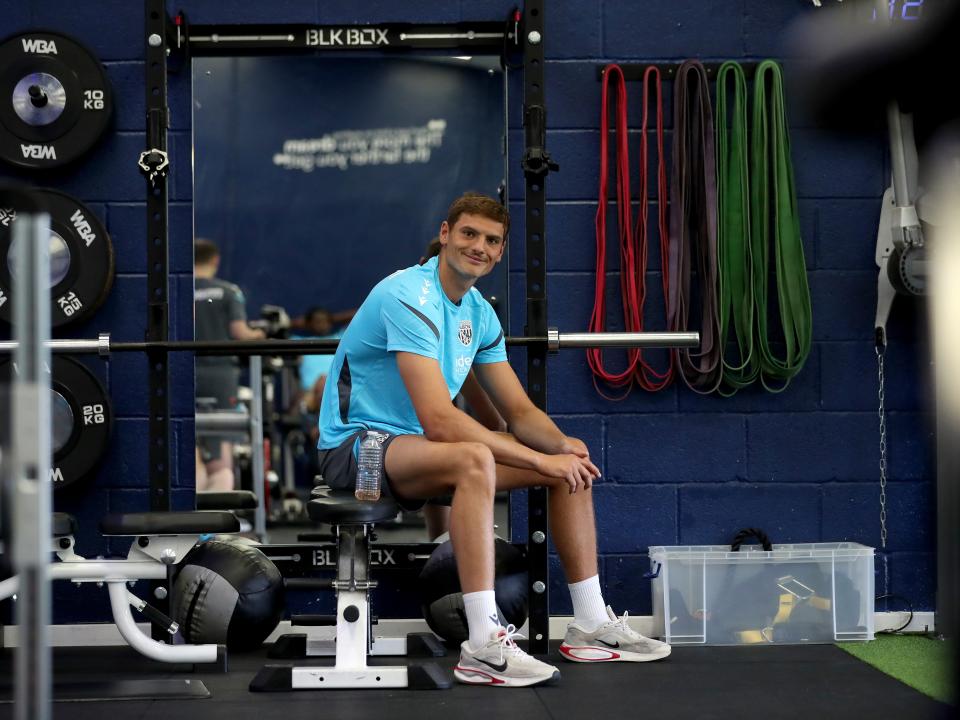 Caleb Taylor sat down in the gym smiling at the camera 
