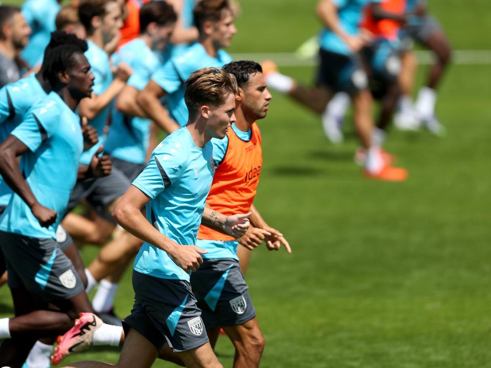 the first-team squad in a line running forward during a training session