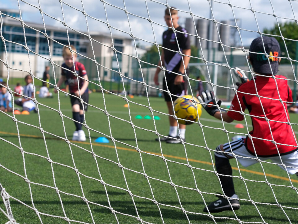 Player taking a penalty with goalkeeper in position to make a save.