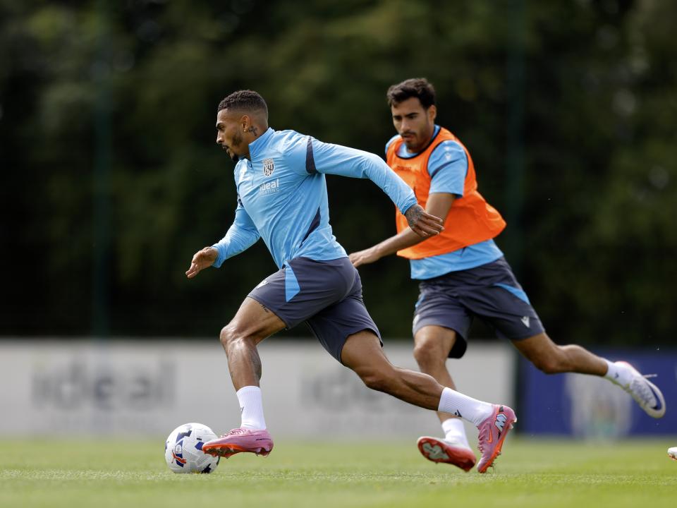 Karlan Grant running with the ball during training, chased by Gianluca Frabotta 