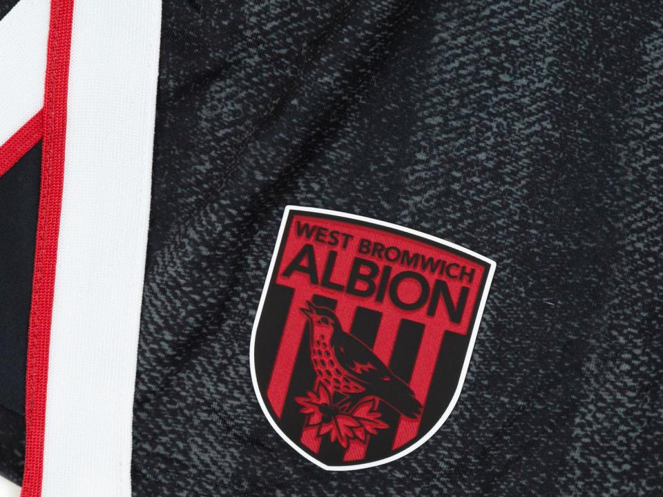 An image of the badge on Albion's black and red third kit