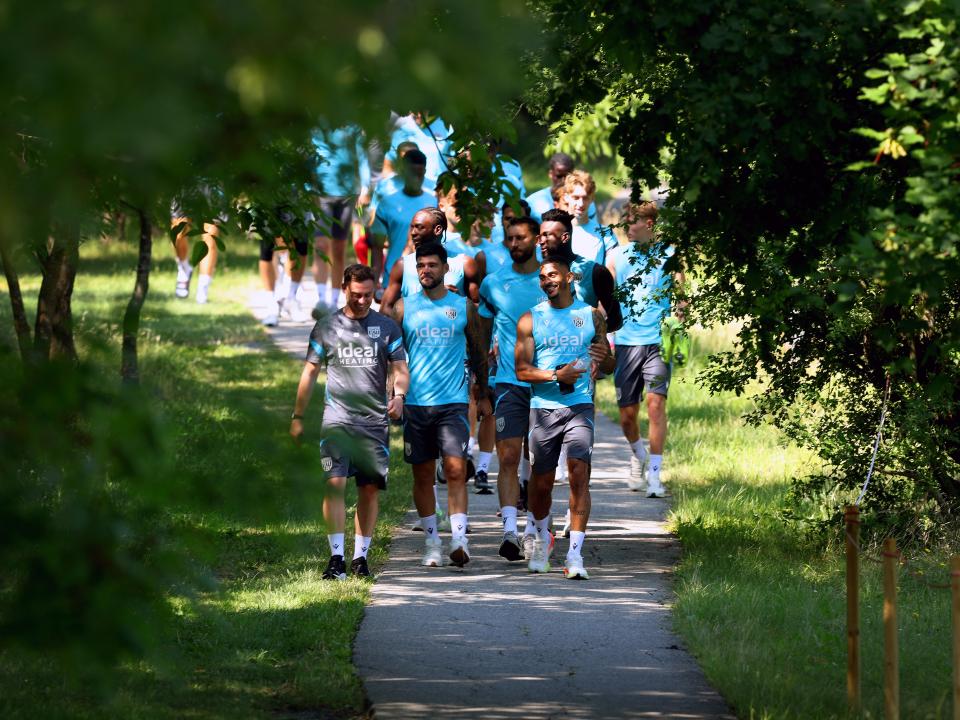 Albion players walking down a path heading to training 