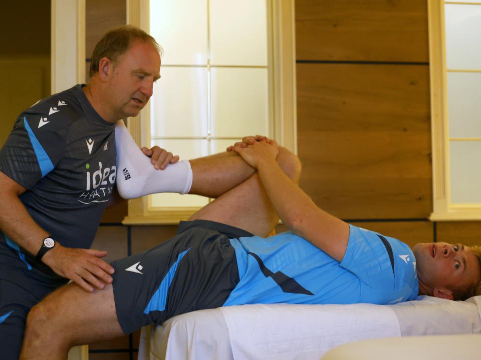 Aune Heggebø stretching with a member of staff on a medical bed