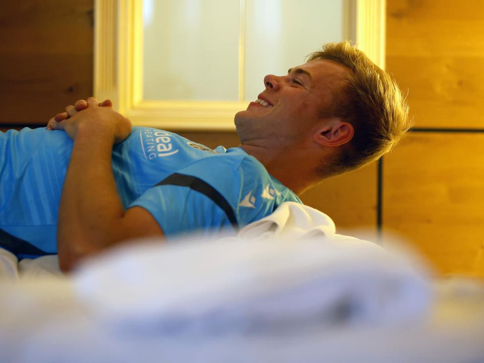 Aune Heggebø smiling while lying on a medical bed