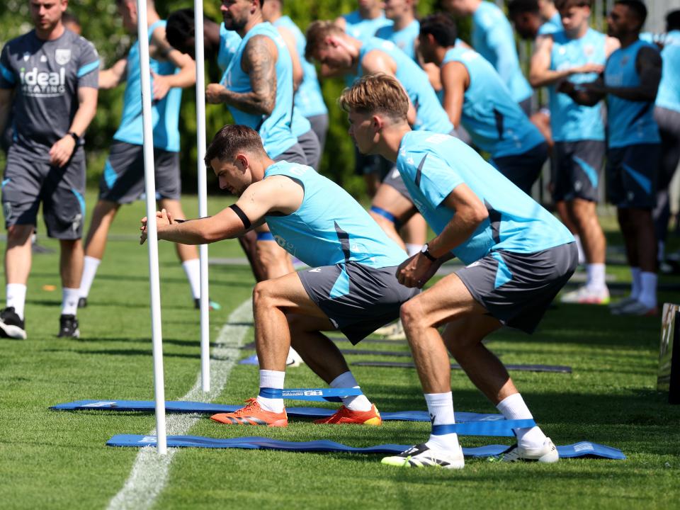 Several Albion players stretching before a training session