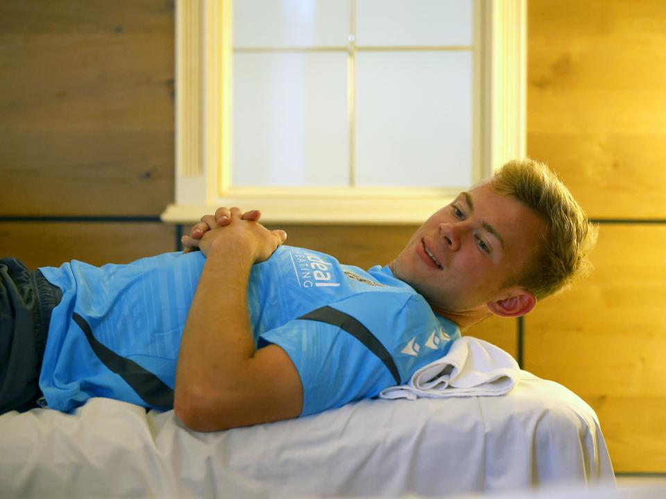 Aune Heggebø smiling while lying on a medical bed