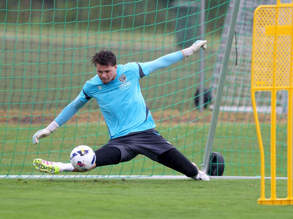 Josh Griffiths saving a shot with his foot during a training session in the rain