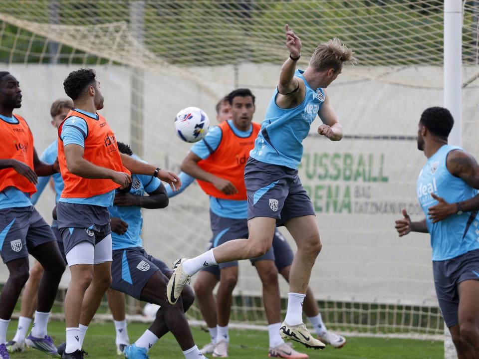 Several players in the penalty area jumping to try and win a header during a training session in Austria 