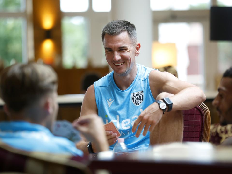 Jed Wallace smiling while playing cards