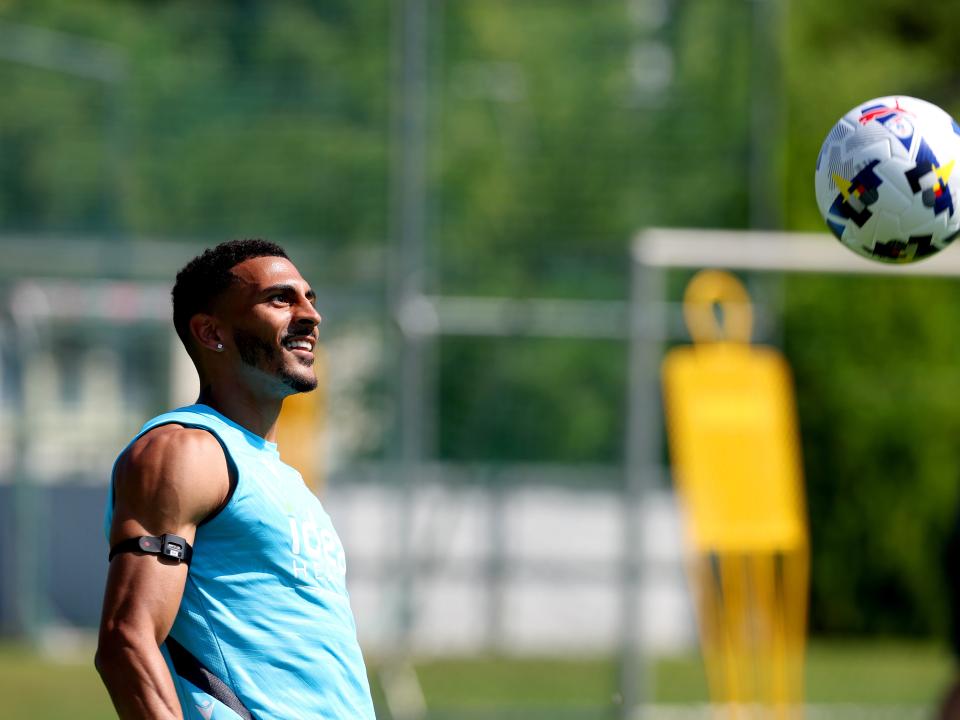 Karlan Grant smiling while keeping his eyes on the ball during a training session