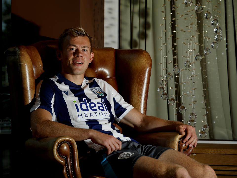 Aune Heggebø smiling at the camera while sat in a WBA shirt in a chair