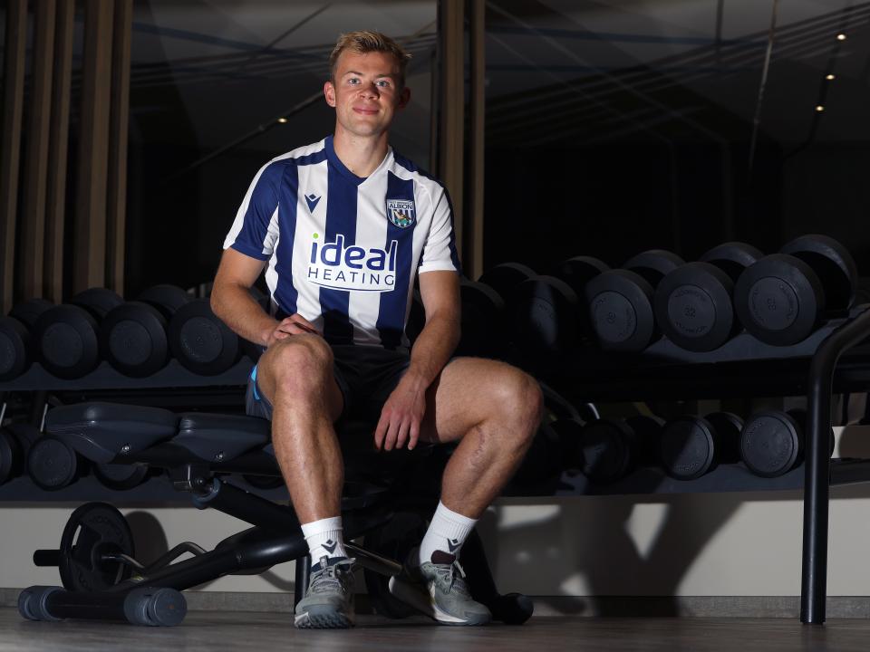 Aune Heggebø smiling at the camera while sat in the gym in a WBA shirt 