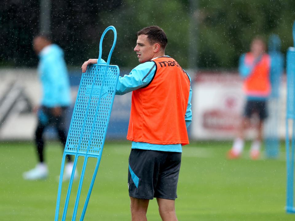 Jayson Molumby looking over a mannequin during a training session in the rain