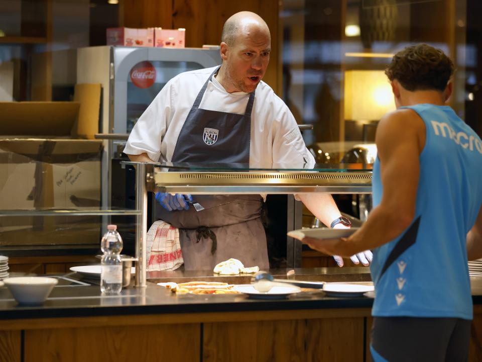 A WBA chef preparing food for a player at the hotel and talking to him