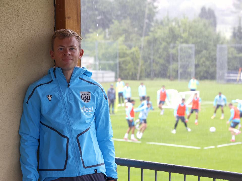 Aune Heggebø smiling at the camera while stood on a balcony watching training in Austria 