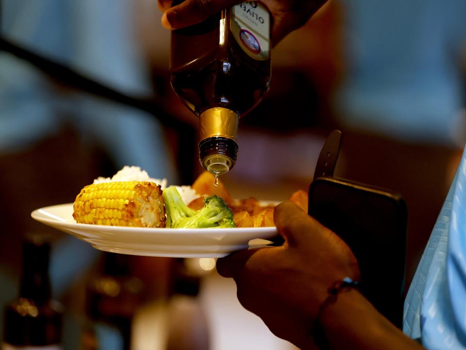 Olive oil being poured on a dinner 