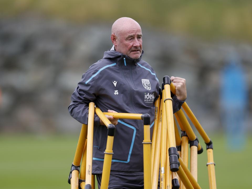 Albion staff member Jacko Smyth carrying equipment on the training pitch in Austria 