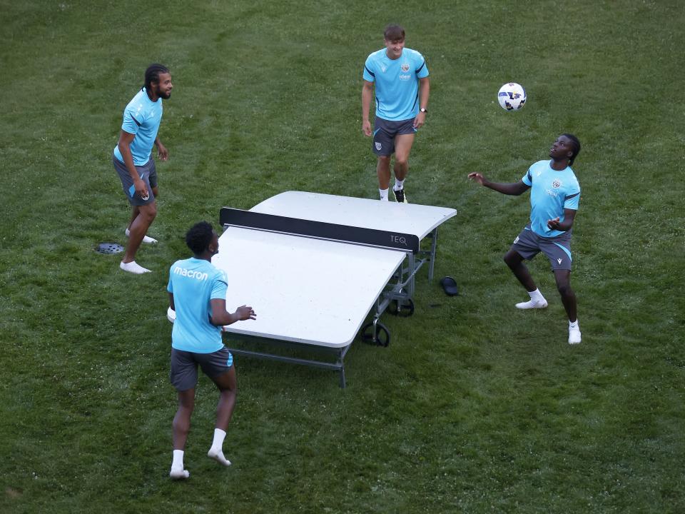 Four young players playing football tennis 