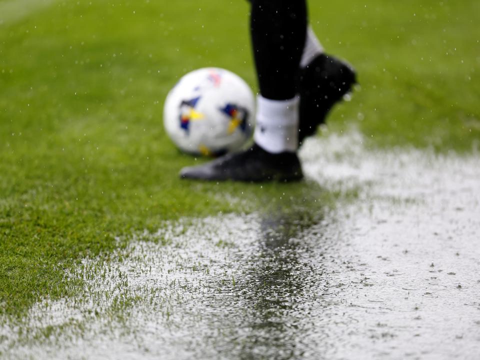 A general view of a rain puddle on the side of the pitch with a ball