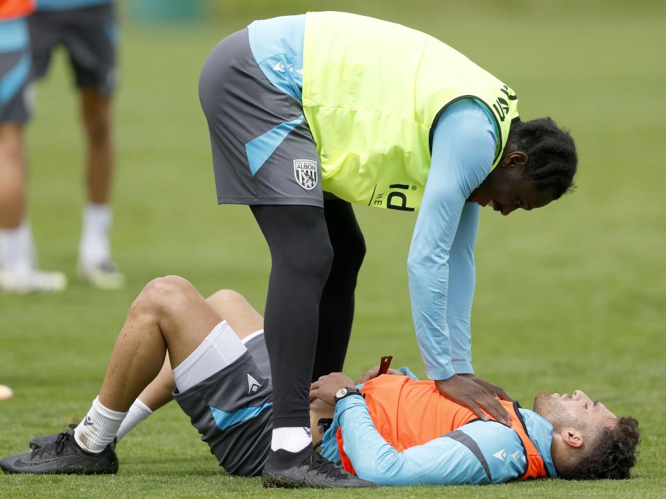 Tammer Bany lying on the ground and Ousmane Diakité standing over him during training 