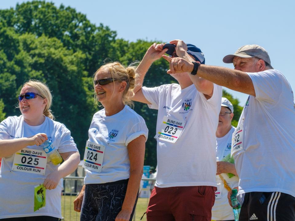 Group of participants smiling and pointing towards the stage.