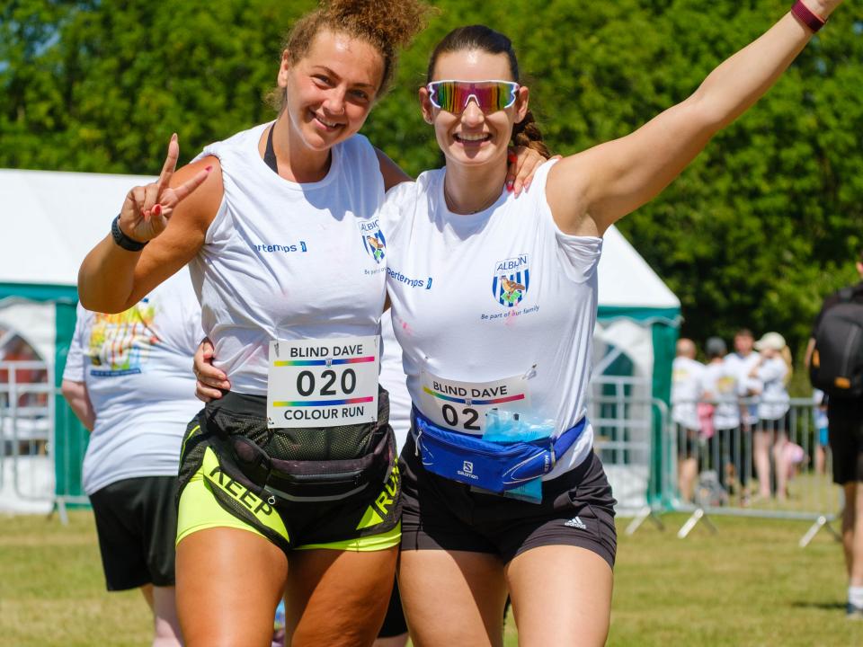 Two participants smiling, one showing a peace sign and the other with arm raised.