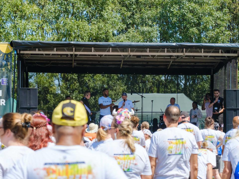 Wide view of participants and the stage, from the back of the crowd.