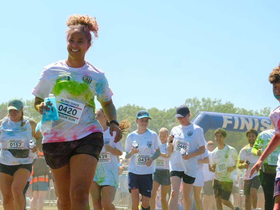 Runners covered in paint, leaving the start line.