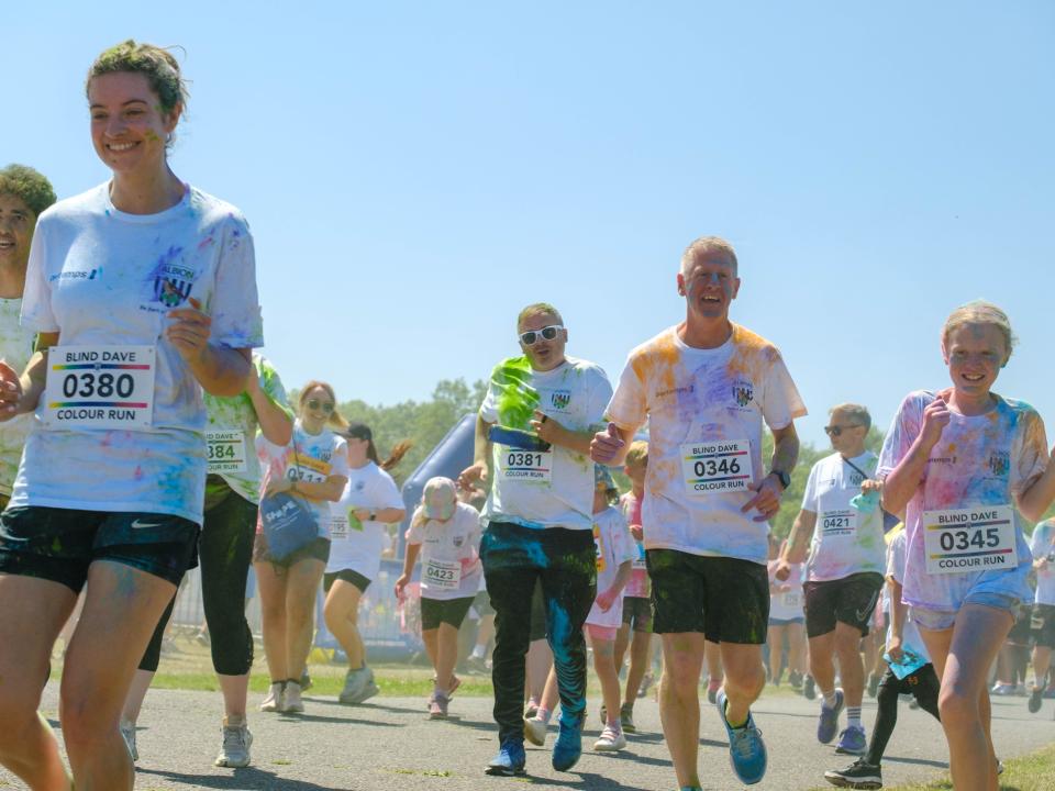 Runners covered in paint, leaving the start line.