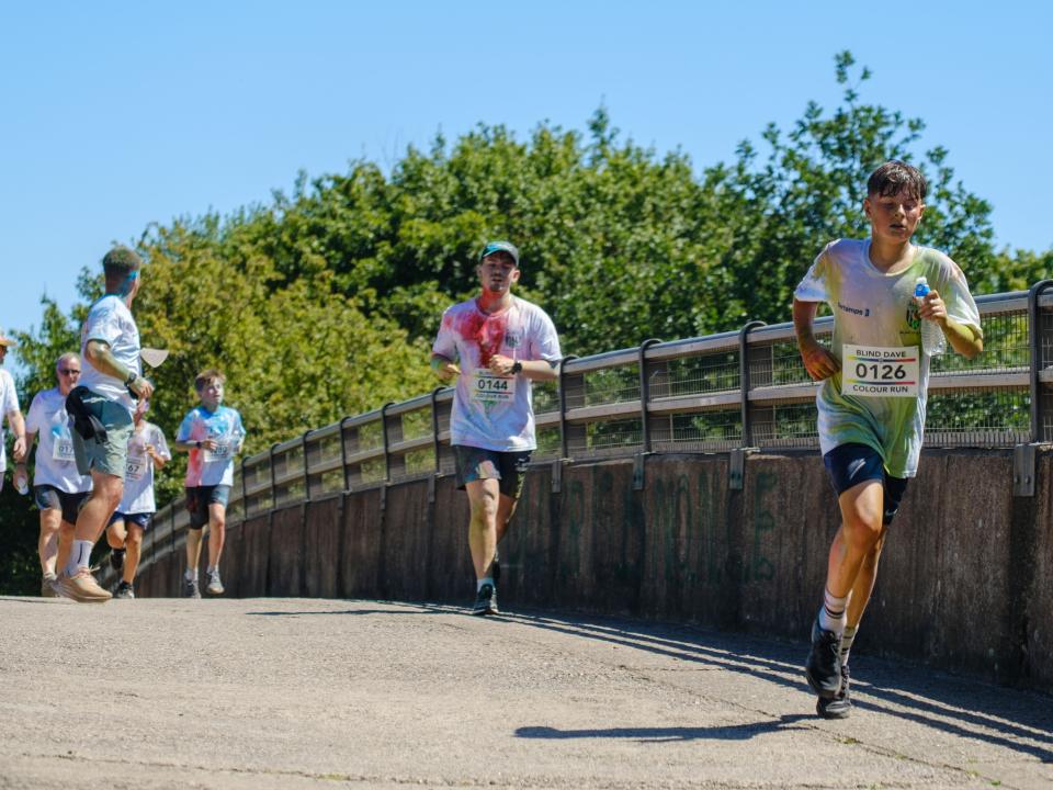 Runners crossing the motorway bridge.