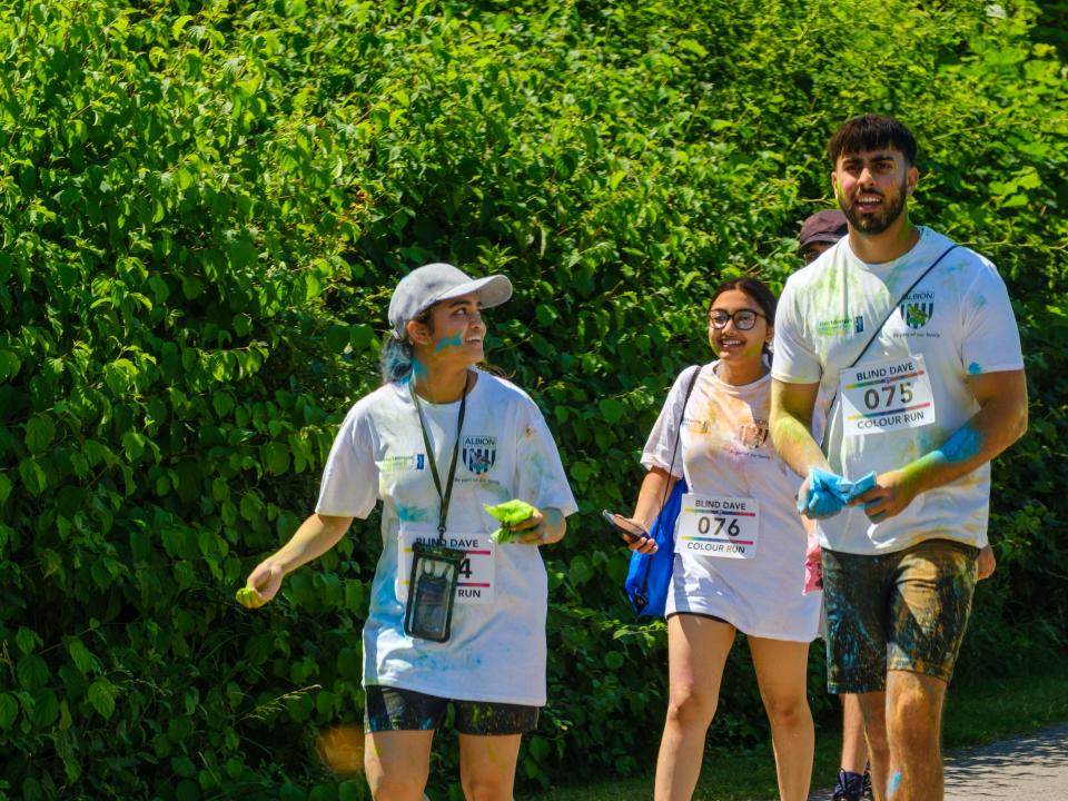 Four runners walking alongside the shrubs.